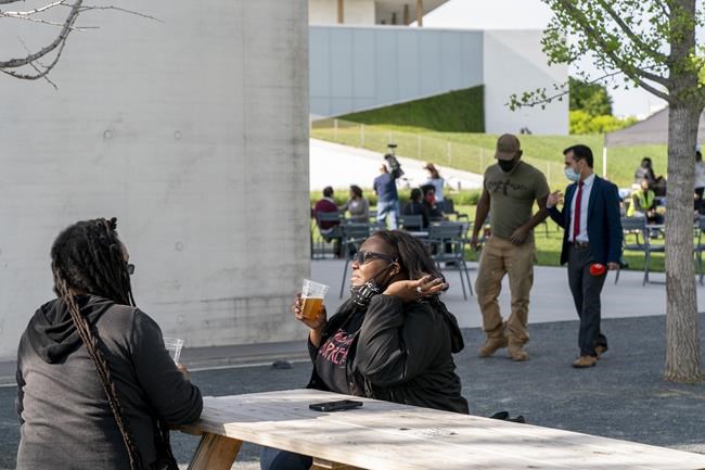 In this May 6, 2021 photo, Semajh Daniels, left, and Zora McCarthy, both of Hyattsville, Md., enjoy a complimentary beer after receiving the J & J COVID-19 vaccine, at The REACH at the Kennedy Center in Washington. Free beer is the latest White House-backed incentive for Americans to get vaccinated for COVID-19. President Joe Biden is expected to announce a “month of action” on Wednesday to get more shots into arms before the July 4 holiday. (AP Photo/Jacquelyn Martin)