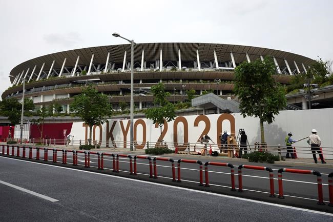 Workers paste the overlay on the wall of the National Stadium, where opening ceremony and many other events are scheduled for the postponed Tokyo 2020 Olympics, Wednesday, June 2, 2021, in Tokyo. THE CANADIAN PRESS/AP/Eugene Hoshiko