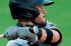 FILE - The Olympic rings are seen on the knob of Miami Marlins' Eddy Alvarez's bat as he swings at a pitch from the Baltimore Orioles during the seventh inning in the first game of a baseball doubleheader in Baltimore, in this Wednesday, Aug. 5, 2020, file photo. Alvarez, having won a silver in speed skating at Sochi in 2014, helped the U.S. reach the Olympic baseball tournament and could become only the third American to win medals at the summer and winter Games. (AP Photo/Julio Cortez, File)