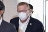 International Olympic Committee Vice President John Coates, center, wearing a face mask, arrives at Haneda Airport in Tokyo Tuesday, June 15, 2021. Coates arrived in Tokyo on Tuesday, the same day organizers and the IOC roll out the final rendition of their so-called Playbooks.(Takuto Kaneko/Kyodo News via AP)