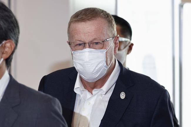 International Olympic Committee Vice President John Coates, center, wearing a face mask, arrives at Haneda Airport in Tokyo Tuesday, June 15, 2021. Coates arrived in Tokyo on Tuesday, the same day organizers and the IOC roll out the final rendition of their so-called Playbooks.(Takuto Kaneko/Kyodo News via AP)