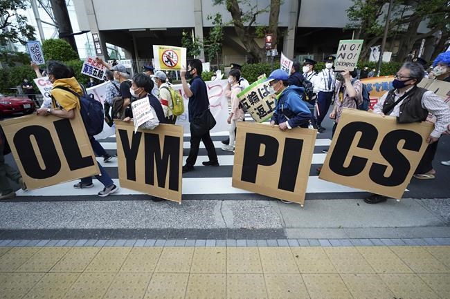 FILE - In this May 9, 2021, file photo, people who are against the Tokyo 2020 Olympics set to open in July, march to protest around Tokyo's National Stadium during an anti-Olympics demonstration. Public sentiment in Japan has been generally opposed to holding the Tokyo Olympics and Paralympics. This is partly based of fears the coronavirus will spike as almost 100,000 people — athletes and others — enter for both events.(AP Photo/Eugene Hoshiko, File)