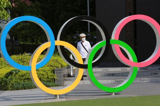 A man walks past the Olympic rings in Tokyo, Monday, June 7, 2021. THE CANADIAN PRESS/AP/Koji Sasahara