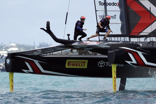 FILE - In this June 26, 2017, file photo, Emirates Team New Zealand helmsman Peter Burling, left, and teammate Blair Tuke cross the boat during the ninth race in America's Cup sailing competition against Oracle Team USA in Hamilton, Bermuda. As they hit what could be the prime of their careers, Burling, 30, and Tuke, 31, are thinking about more than just their next victory. Sure, they're focusing in on trying to win another gold medal in the high-performance 49er skiff in the Tokyo Olympics starting later this month. They also realize that as the victories pile up, they're in a unique position to speak out about protecting the planet's oceans. (AP Photo/Gregory Bull, File)