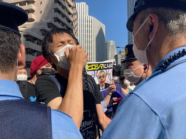 Protesters against the Olympic and Paralympic Games (Tokyo 2020) confront police officers in Tokyo, Saturday, July 10, 2021. The poster, center, reads,