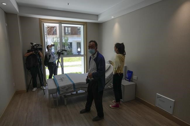 Journalists film an electric-powered bed for athletes at the Olympics Village for Beijing 2022 Olympic and Paralympic Winter Games and Paralympic Winter Games, during a media tour in Zhangjiakou in northwestern China's Hebei province on Wednesday, July 14, 2021. (AP Photo/Andy Wong)