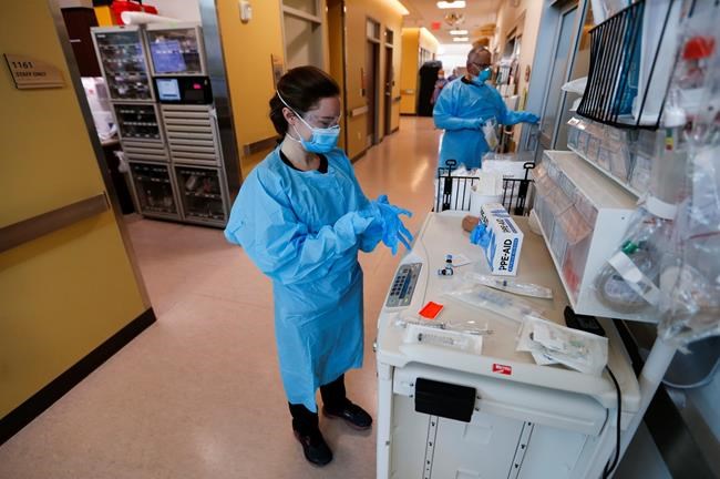 Nurses and doctors in the CoxHealth Emergency Department in Springfield, Mo., don personal protective equipment to treat patients with COVID-19, Friday, July 16, 2021. Southwest Missouri is seeing a surge in Delta variant cases, with hospitals nearing capacity and requesting help from the state for staffing and an alternative care site. (Nathan Papes/The Springfield News-Leader via AP)