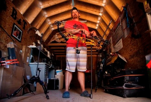 FILE - In this April 30, 2020, file photo, U.S. Olympic Team archer Brady Ellison pauses with a compound bow at his range on his farm in Miami, Ariz. The playbook for athletes provides a guide to a 