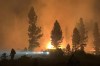 In this photo provided by the Bootleg Fire Incident Command, the Bootleg Fire burns at night in southern Oregon on Saturday, July 17, 2021. The destructive Bootleg Fire, one of the largest in modern Oregon history, has already burned more than 476 square miles (1,210 square kilometers), an area about the size of Los Angeles. The Bootleg Fire is among dozens burning in the parched West. (Bootleg Fire Incident Command via AP)
