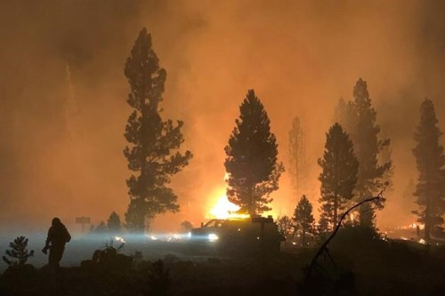 In this photo provided by the Bootleg Fire Incident Command, the Bootleg Fire burns at night in southern Oregon on Saturday, July 17, 2021. The destructive Bootleg Fire, one of the largest in modern Oregon history, has already burned more than 476 square miles (1,210 square kilometers), an area about the size of Los Angeles. The Bootleg Fire is among dozens burning in the parched West. (Bootleg Fire Incident Command via AP)