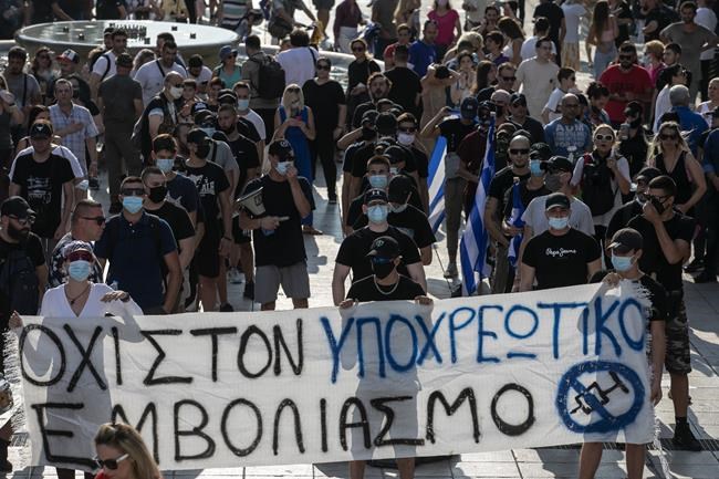Anti-vaccine protesters hold a banner during a rally at Syntagma square, central Athens, on Wednesday, July 21, 2021. Thousands of people protested against Greek government's measures to curb rising COVID-19 infections and drive up vaccinations in the country where almost 50% of Greeks and country residents have received at least one dose of the vaccine. The banner reads :