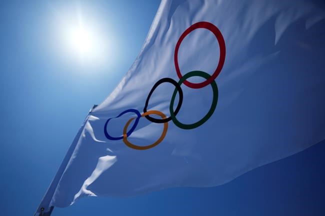 An Olympic flag flies over the top of the bleachers at Ariake Tennis Center, Monday, July 19, 2021, in Tokyo. (AP Photo/Kiichiro Sato)