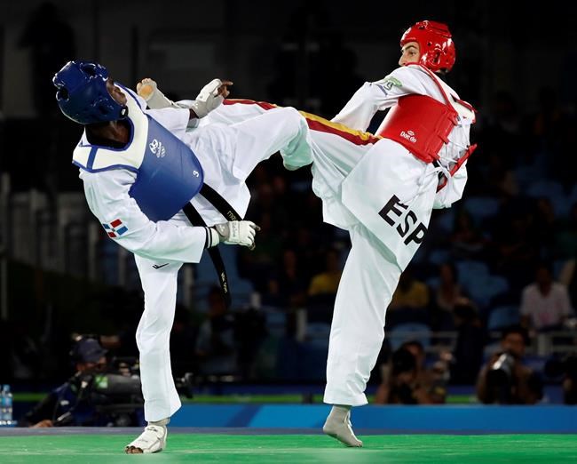 FILE - In this Aug. 17, 2016, file photo, Luisito Pie, of the Dominican Republic, left, and Jesus Tortosa, of Spain, compete in a men's Taekwondo bronze medal final at the 2016 Summer Olympics in Rio de Janeiro, Brazil, Wednesday, Aug. 17, 2016. One of the world's top-ranked taekwondo fighters is taking vacation in the Dominican Republic instead of competing at the Tokyo Olympics after being surprisingly excluded from the Games by the Spanish federation. Tortosa is among a few athletes worldwide who earned Olympic qualification but won’t be in Japan because in some sports the final decision on picking the teams is made by the local federations. (AP Photo/Andrew Medichini, File)