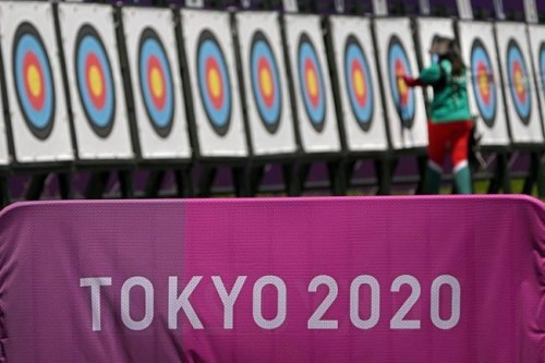 An athlete collects her arrows as she practices for the 2020 Summer Olympics at Yumenoshima Park Archery Field, Sunday, July 18, 2021, in Tokyo. (AP Photo/Charlie Riedel)