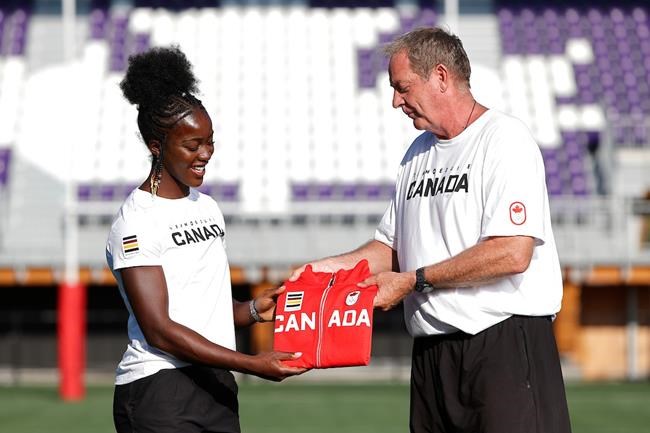 Interim Canada women’s rugby sevens coach Mick Byrne hands Pamphinette Buisa her Team Canada jacket on June 25, 2021 in Langford, B.C., when the Canadian Olympic sevens team was named. THE CANADIAN PRESS/HO-Rugby Canada-Kevin Light MANDATORY CREDIT
