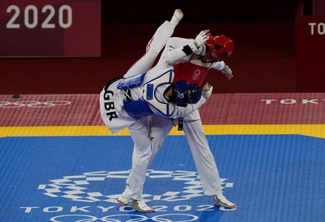 Kimia Alizadeh Zonoozi, Refugee Olympic Team, right, is attacked by Britain's Jade Jones during the taekwondo women's 57kg match at the 2020 Summer Olympics, Sunday, July 25, 2021, in Tokyo, Japan. (AP Photo/Themba Hadebe)