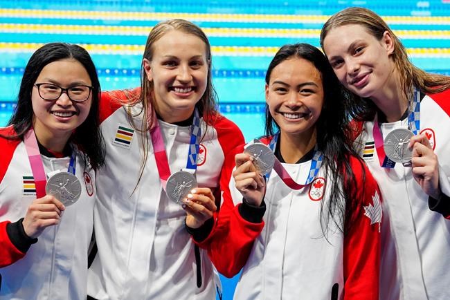 Canada's Margaret Mac Neil, left to right, Rebecca Smith, Kayla Sanchez and Penny Oleksiak celebrate a silver medal in the women's 4 x 100m freestyle relay during the Tokyo Olympics in Tokyo, Japan on Sunday, July 25, 2021. THE CANADIAN PRESS/Frank Gunn