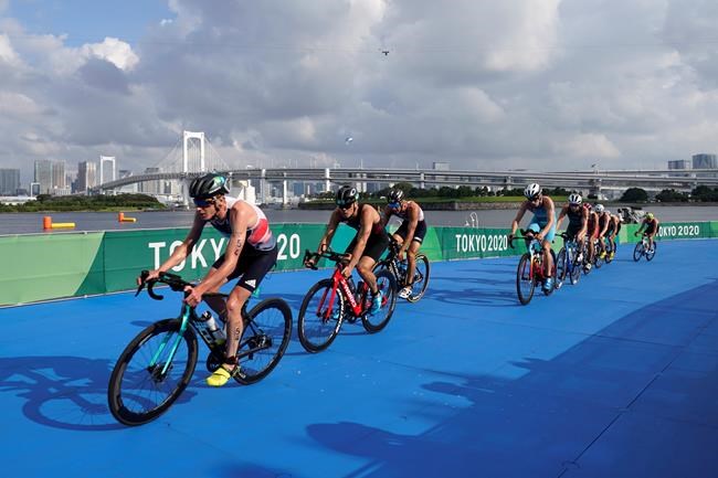 Left to right, Jonathan Brownlee of Great Britain (54), Kenji Nener of Japan (30),Vincent Luis of France (7), Marten van Riel of Belgium (27), Henri Schoeman of South Africa (51), Tyler Mislawchuk of Canada (15), Vincent Luis of France (7), Jonas Schomburg of Germany (4) and Dmitry Polyanskiy of the Russian Olympic Committee (8) chase the lead group during the cycling leg of the men's individual triathlon at the 2020 Summer Olympics, Monday, July 26, 2021, in Tokyo, Japan. (AP Photo/Jae C. Hong)