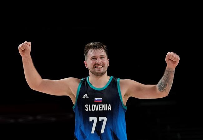 Slovenia's Luka Doncic (77) celebrates scoring by a teammate during men's basketball preliminary round game against Argentina at the 2020 Summer Olympics, Monday, July 26, 2021, in Saitama, Japan. (AP Photo/Eric Gay)