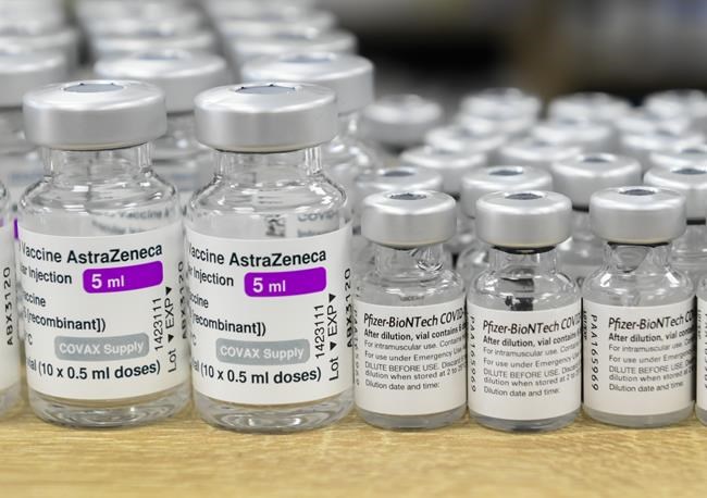 Vials of both Pfizer-BioNTech and Oxford-AstraZeneca COVID-19 vaccines sit on a counter at the Junction Chemist Pharmacy, in Toronto, Friday, June 18, 2021. Ontario has asked the federal government to ensure Canadians who received mixed COVID-19 vaccines will be recognized for international travel as border measures lift.THE CANADIAN PRESS/Nathan Denette
