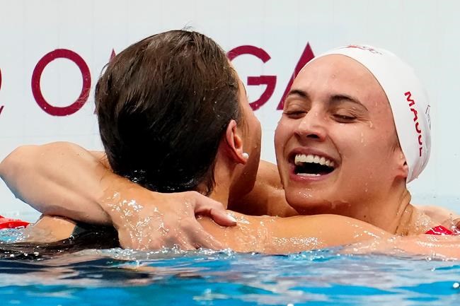 Canada's Kylie Masse embraces gold medal winner, Australia's Kaylee McKeown, after competing to win silver in the women's 100m backstroke final event during the Tokyo Summer Olympic Games, in Tokyo, Tuesday, July 27, 2021. THE CANADIAN PRESS/Frank Gunn
