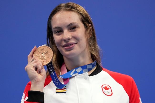 Penny Oleksiak of Canada holds up her bronze medal from the women's 200-meter freestyle final at the 2020 Summer Olympics, Wednesday, July 28, 2021, in Tokyo, Japan. THE CANADIAN PRESS/AP/Matthias Schrader