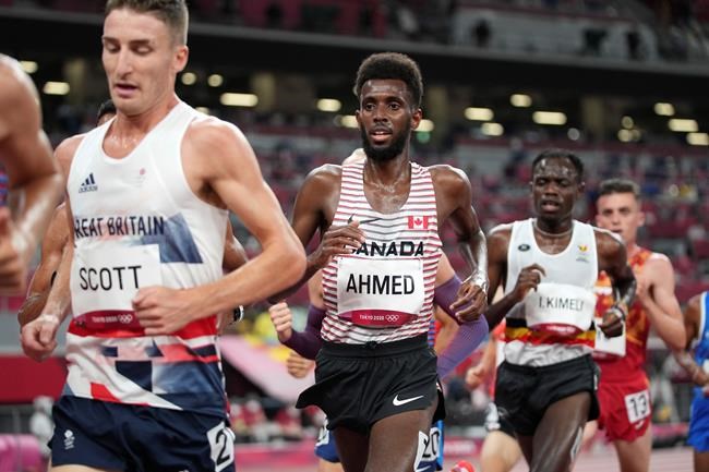 Mohammed Ahmed, centre, of Canada, runs in the men's 10,000-meters final at the 2020 Summer Olympics, in Tokyo, Friday, July 30, 2021. Ahmed looked headed for a medal, but he couldn't maintain the pace and faded over the final 300 metres to finish sixth in the 10,000 on Friday at the Tokyo Olympics, his first time racing the distance since the 2019 world championships. THE CANADIAN PRESS/AP-Matthias Schrader