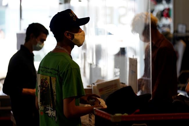 FILE - In this July 19 2021 file photo, employees check out customers at 2nd Street second hand store in the Fairfax district of Los Angeles. New evidence showing the delta variant is as contagious as chickenpox has prompted U.S. health officials to consider changing advice on how the nation fights the coronavirus. Recommending masks for everyone and requiring vaccines for doctors and other health care providers are among measures the Centers for Disease Control and Prevention is considering, Friday, July 30. (AP Photo/Marcio Jose Sanchez, File)