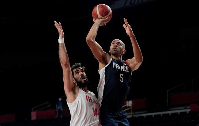 France's Nicolas Batum (5), right, shoots over Iran's Mohammadsamad Nik Khahbahrami (14) during men's basketball preliminary round game at the 2020 Summer Olympics, Saturday, July 31, 2021, in Saitama, Japan. (AP Photo/Eric Gay)