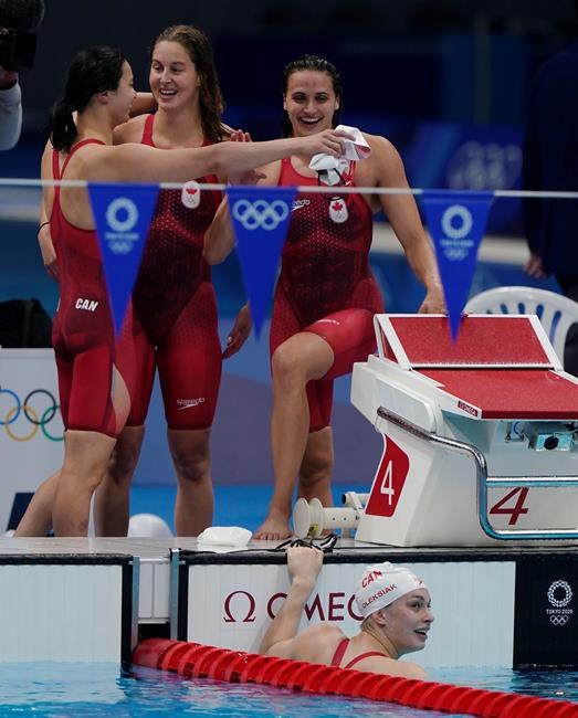 Canada's Maggie Mac Neil, left to right, Sydney Pickrem, Kylie Masse and Penny Oleksiak, in the water, celebrate a bronze medal in the women's 4 x 100m medley relay final during the Tokyo Summer Olympic Games, in Tokyo, Sunday, August 1, 2021. THE CANADIAN PRESS/Adrian Wyld