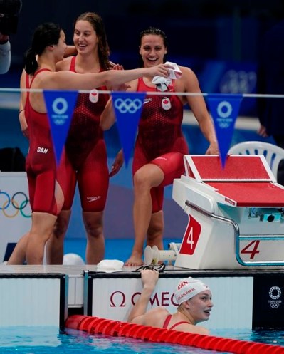 Canada's Maggie Mac Neil, left to right, Sydney Pickrem, Kylie Masse and Penny Oleksiak, in the water, celebrate a bronze medal in the women's 4 x 100m medley relay final during the Tokyo Summer Olympic Games, in Tokyo, Sunday, August 1, 2021. THE CANADIAN PRESS/Adrian Wyld