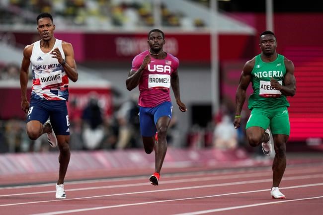 Trayvon Bromell, of United States, center, finishes a heat in the men's 100-meter run at the 2020 Summer Olympics, Saturday, July 31, 2021, in Tokyo. (AP Photo/Petr David Josek)