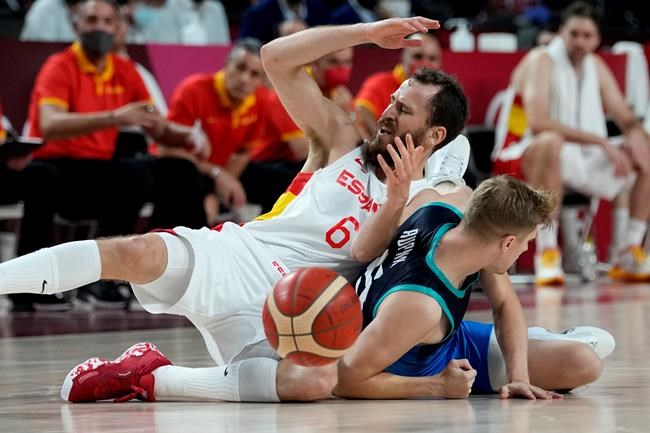 Spain's Sergio Rodriguez (6) and Slovenia's Luka Rupnik (5) fall to the floor during a men's basketball preliminary round game at the 2020 Summer Olympics, Sunday, Aug. 1, 2021, in Saitama, Japan. (AP Photo/Eric Gay)