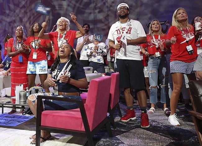 Venus Jewett, back left, mother of Olympic runner Isaiah Jewett, watches her son compete in the 800-meter race and reacts as as Isaiah failed to make the finals as she joins other family and friends of Olympic athletes watching the televised action live at the Olympic Family & Friends Experience at the Loews Sapphire Falls Resort at Universal Orlando in Orlando, Fla., Friday, July 30, 2021. Parents, siblings, friends and former teammates crowd into the ballroom at the resort daily to watch the Summer Games and bond with others in a similar situation, all of them unable to be in Tokyo to root on their loved ones competing for gold because of the coronavirus pandemic. (Stephen M. Dowell/Orlando Sentinel via AP)