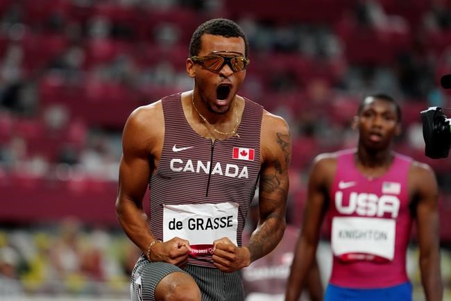 Canada's Andre De Grasse reacts after racing to a gold medal as American Erriyon Knighton looks on in the Men's 200m final during the Tokyo Olympics in Tokyo, Japan on Wednesday, August 4, 2021. After two days without any medals at the Tokyo Olympics, Andre De Grasse got Canada back on the board with the greatest run of his stellar career. THE CANADIAN PRESS/Frank Gunn