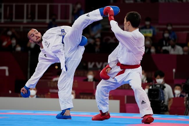 Darkhan Assadilov of Kazakhstan, right, and Steven da Costa of France compete in the men's kumite -67kg semifinal bout for Karate at the 2020 Summer Olympics, Thursday, Aug. 5, 2021, in Tokyo, Japan. (AP Photo/Vincent Thian)