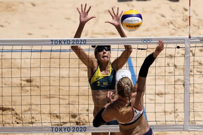 April Ross, right, of the United States, takes a shot as Mariafe Artacho del Solar, of Australia, defends during a women's beach volleyball Gold Medal match at the 2020 Summer Olympics, Friday, Aug. 6, 2021, in Tokyo, Japan. (AP Photo/Petros Giannakouris)