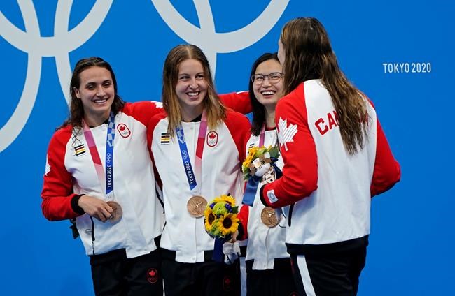 Canada's Kylie Masse, left to right, Sydney Pickrem, Maggie Mac Neil and Penny Oleksiak celebrate a bronze medal in the women's 4 x 100m medley relay final during the Tokyo Summer Olympic Games, in Tokyo on August 1, 2021. THE CANADIAN PRESS/Adrian Wyld