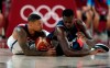 United States' Damian Lillard (6), left, and France's Moustapha Fall (93) fight for a loose ball during men's basketball gold medal game at the 2020 Summer Olympics, Saturday, Aug. 7, 2021, in Saitama, Japan. (AP Photo/Charlie Neibergall)