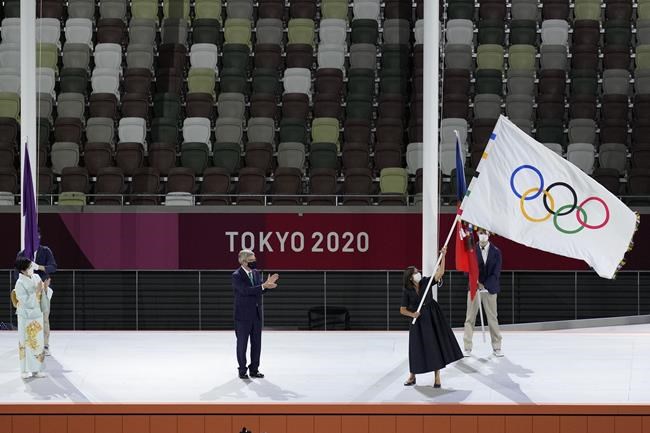 Paris mayor Anne Hidalgo, right, holds the Olympic flag next International Olympic Committee's President Thomas Bach, center, and Tokyo Gov. Yuriko Koike, left, during the closing ceremony in the Olympic Stadium at the 2020 Summer Olympics, Sunday, Aug. 8, 2021, in Tokyo, Japan. (AP Photo/Lee Jin-man)