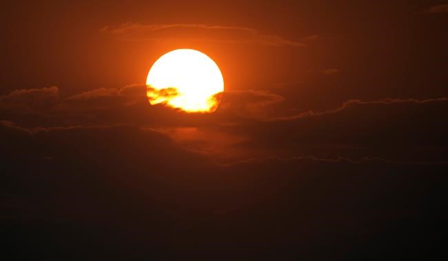 The sky turns read as the sun sets behind the Rocky Mountains obscured by smoke flowing along Colorado's Front Range from wildfires across the West Monday, Aug. 9, 2021, in Denver. Forecasters predict that the hot weather will persist through the week ahead as will the constant flow of smoke, which has enveloped the Intermountain West for weeks. (AP Photo/David Zalubowski)