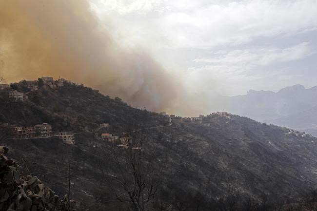 Smoke and fires threaten a village near Tizi Ouzou some 100 km (62 miles) east of Algiers following wildfires in this mountainous region, Tuesday, Aug.10, 2021. Firefighters were battling a rash of fires in northern Algeria that have killed at least six people in the mountainous Kabyle region, the interior minister said Tuesday, accusing