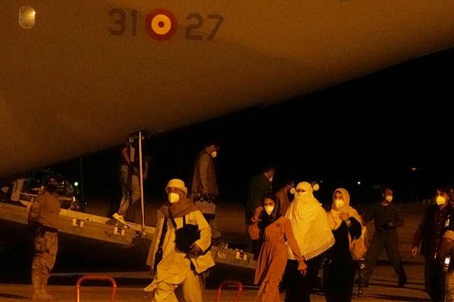 People arrive on a Spanish Air Force plane carrying Spanish nationals and Afghans at the Torrejon military base as part of the evacuation process in Madrid, Spain, Thursday, Aug. 19, 2021. (AP Photo/Paul White)