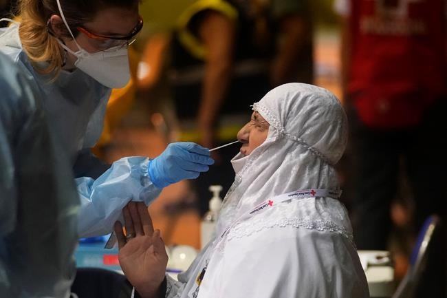 An Afghan woman gets the coronavirus test on arriving on Spanish airforce plane carrying Spanish nationals and Afghans after it landed at the Torrejon military base as part of the evacuation process in Madrid, Spain, Thursday, Aug. 19, 2021. (AP Photo/Paul White)