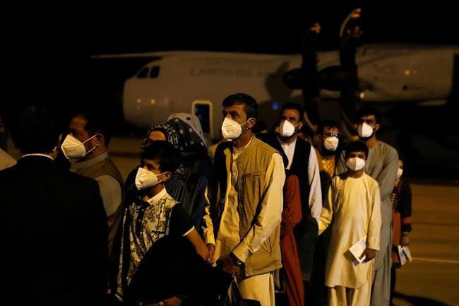 People leave a Spanish airforce plane carrying Spanish nationals and Afghans after it landed at the Torrejon military base as part of the evacuation process in Madrid, Spain, Thursday, Aug. 19, 2021. (AP Photo/Paul White)