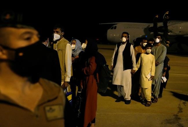 People leave a Spanish airforce plane carrying Spanish nationals and Afghans after it landed at the Torrejon military base as part of the evacuation process in Madrid, Spain, Thursday, Aug. 19, 2021. (AP Photo/Paul White)