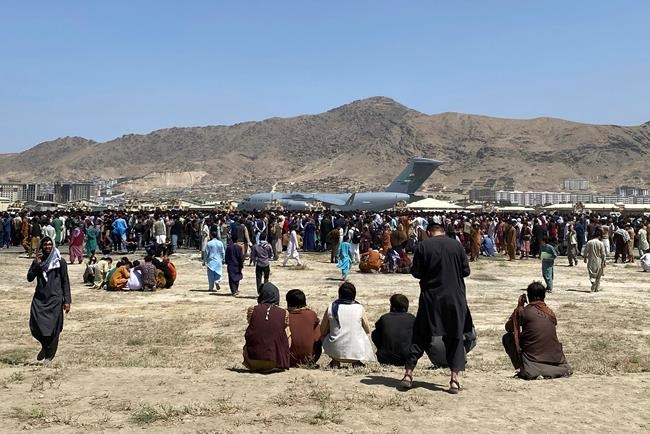 Hundreds of people gather near a U.S. Air Force C-17 transport plane at the perimeter of the international airport in Kabul, Afghanistan, Monday, Aug. 16, 2021. THE CANADIAN PRESS/AP, Shekib Rahmani