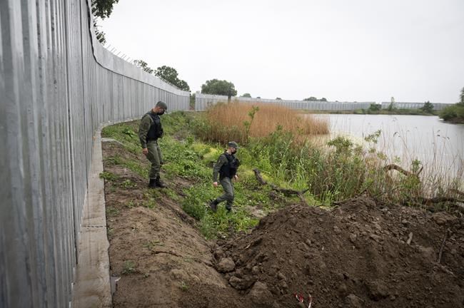 FILE - In this Friday, May 21, 2021, policemen patrol alongside a steel wall at Evros river, near the village of Poros, at the Greek -Turkish border, Greece. Greece's prime minister and Turkey's president are to speak Friday evening, Aug. 20, to discuss