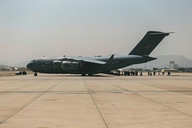 In this image provided by the U.S. Marine Corps, evacuees load on to a Boeing C-17 Globemaster III during an evacuation at Hamid Karzai International Airport in Kabul, Afghanistan, Friday, Aug. 20, 2021. (Sgt. Isaiah Campbell/U.S. Marine Corps via AP)
