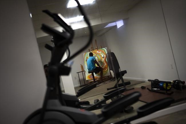 Freddie De Los Santos paints a canvas in his basement in Hopewell Junction, N.Y., on Wednesday, Aug. 19, 2021. “I have days where you see me moving and laughing, but I’m not functioning very well,” he says.
